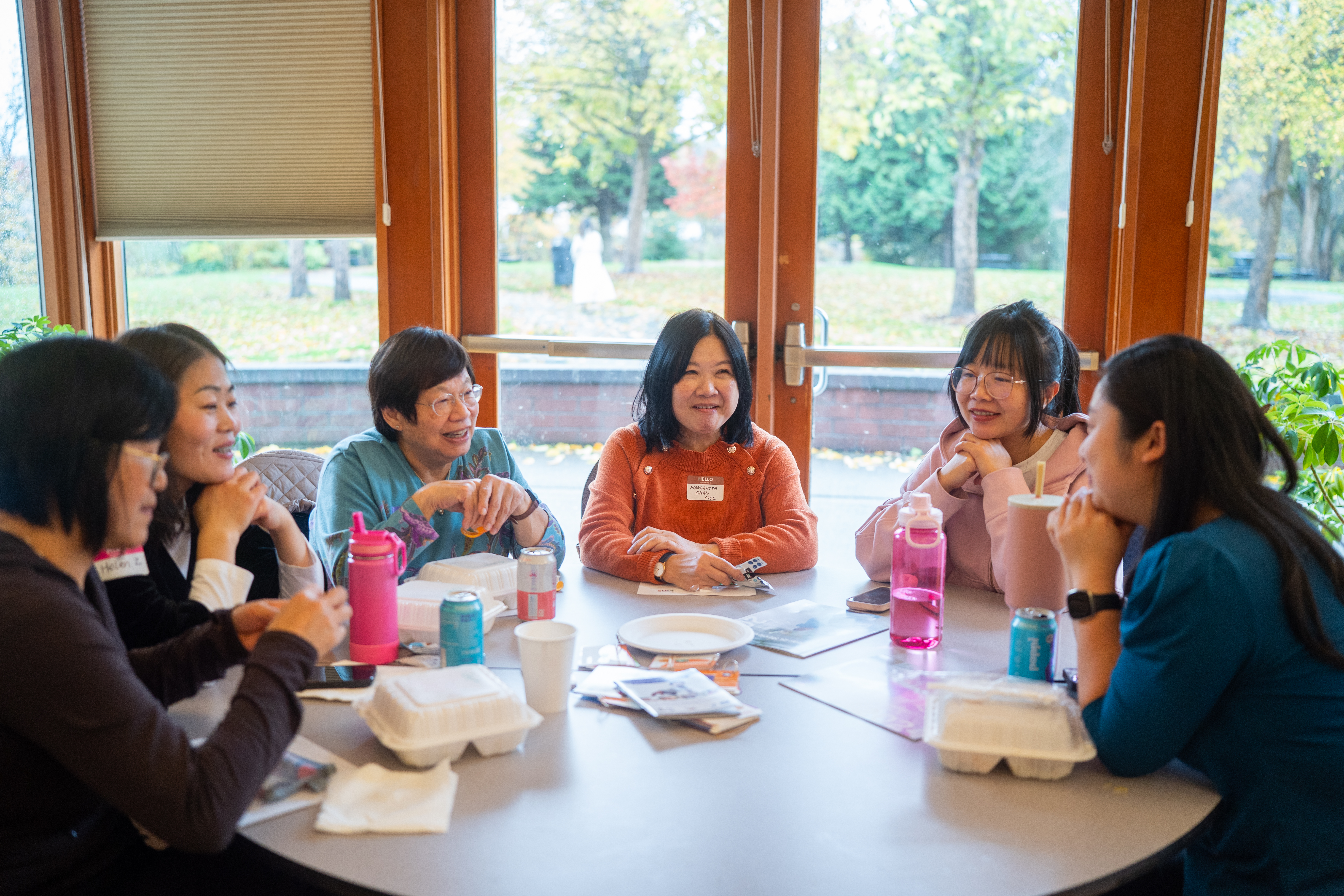 Community members sitting around a table and talking.
